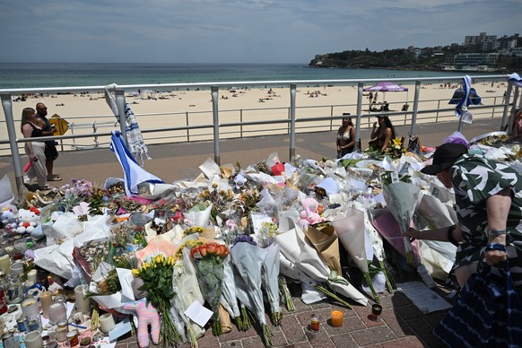 epa12606406 People continue to bring flowers to the Bondi Beach promenade as crowds return to Bondi Beach on the a day of National Reflection one week on from the Bondi Massacre in Sydney, Australia,  ...