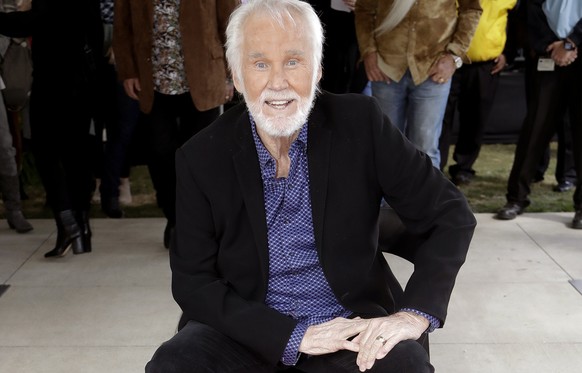 FILE - In this Oct. 24, 2017 file photo, Kenny Rogers poses with his star on the Music City Walk of Fame in Nashville, Tenn. Actor-singer Kenny Rogers, the smooth, Grammy-winning balladeer who spanned ...
