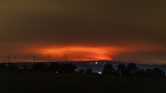 Nachtaufnahme: Waldbrand im Hohen Venn hinter Windkraftr�dern bei Kleinhau Nachtaufnahme aus Kleinhau Gemeinde H�rtgenwald: Am Horizont, rund 26 Kilometer entfernt in Belgien, erhellt r�tlicher Flamme ...