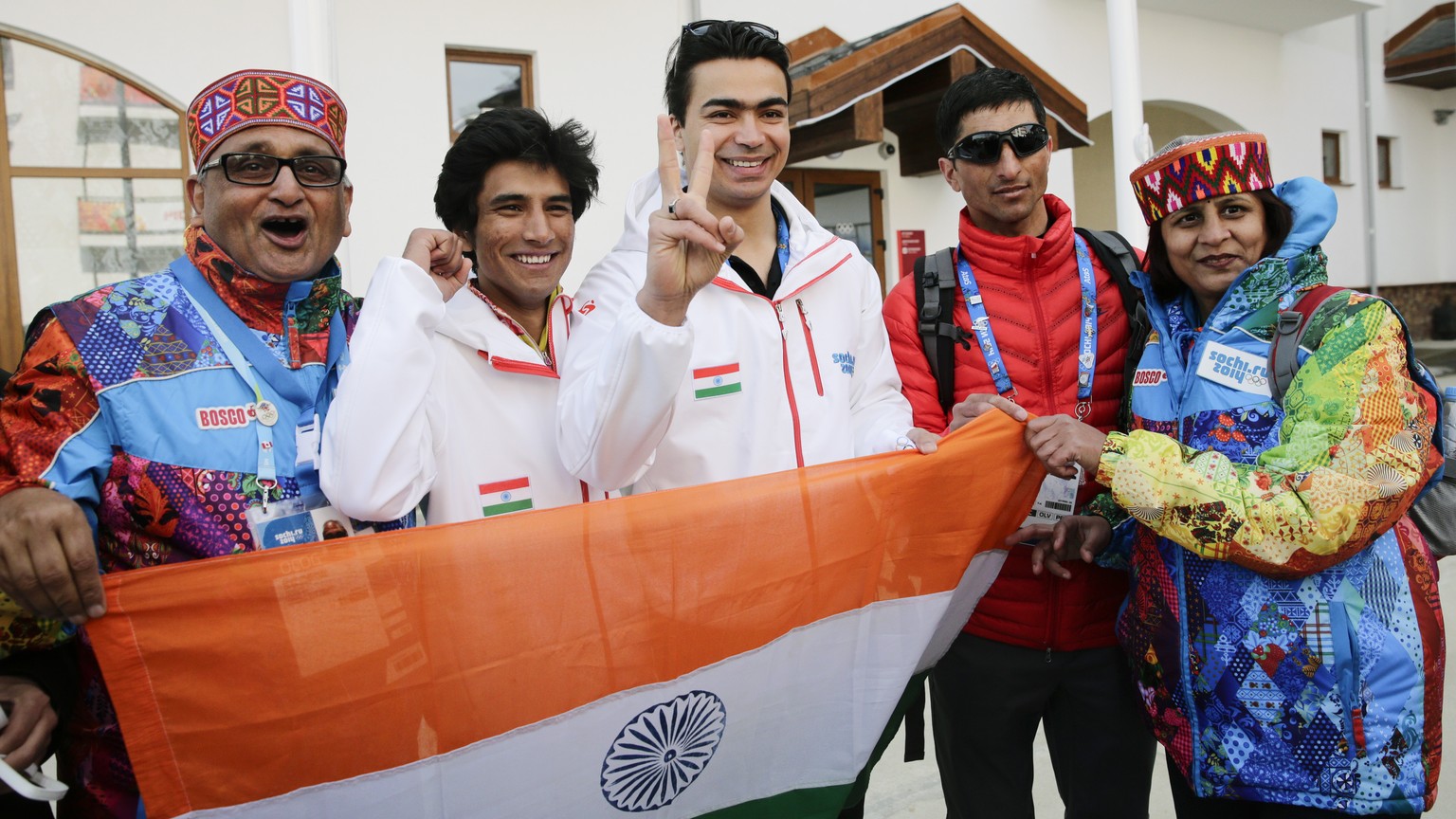 Indian athletes, alpine skier Thakur Himanshu, second left, luger Shiva Keshavan, center, and cross-country skier Nadeem Iqbal, second right, pause for photos after a welcome ceremony for the Indian O ...