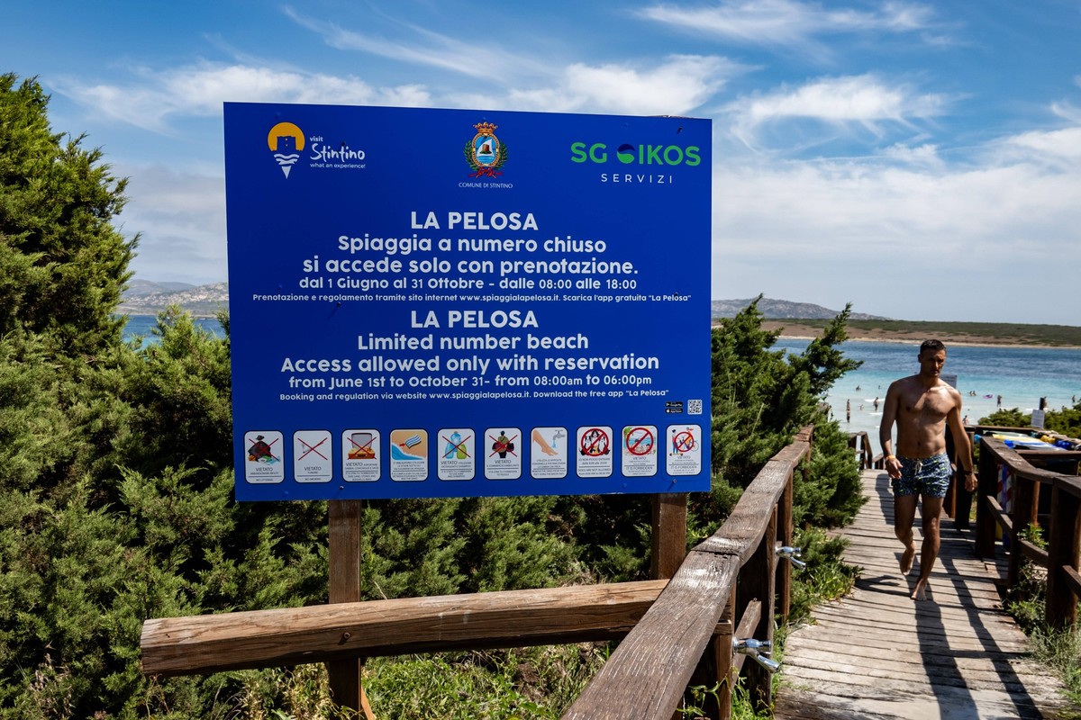 Travel Destination: Sardinia A warning board showing the rules and indicating the closed number access is being pictured by La Pelosa beach in Stintino, Sardinia, Italy, on August 5, 2024. La Pelosa b ...