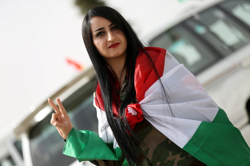 epa06226354 A female Kurdish Peshmerga soldier flashes the victory sign during Kurdistan independence referendum in Erbil, Kurdistan region in northern Iraq, 25 September 2017. The Kurdistan region is ...