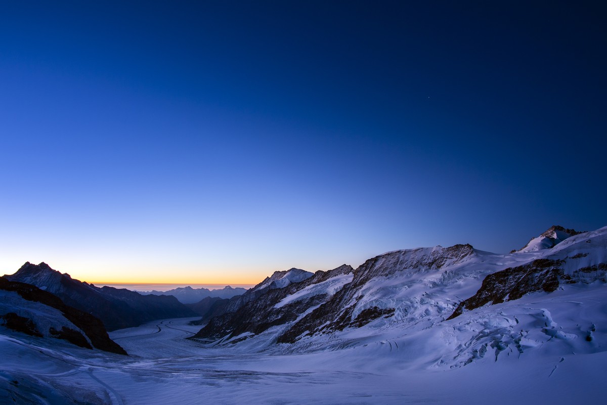 The sun is rising behind the Jungfraufirn and the Aletsch Glacier. Picture was taken from the Jungfraujoch, 3'454 meters above sea level, in the Bernese Alps on the boundary between the canton of ...