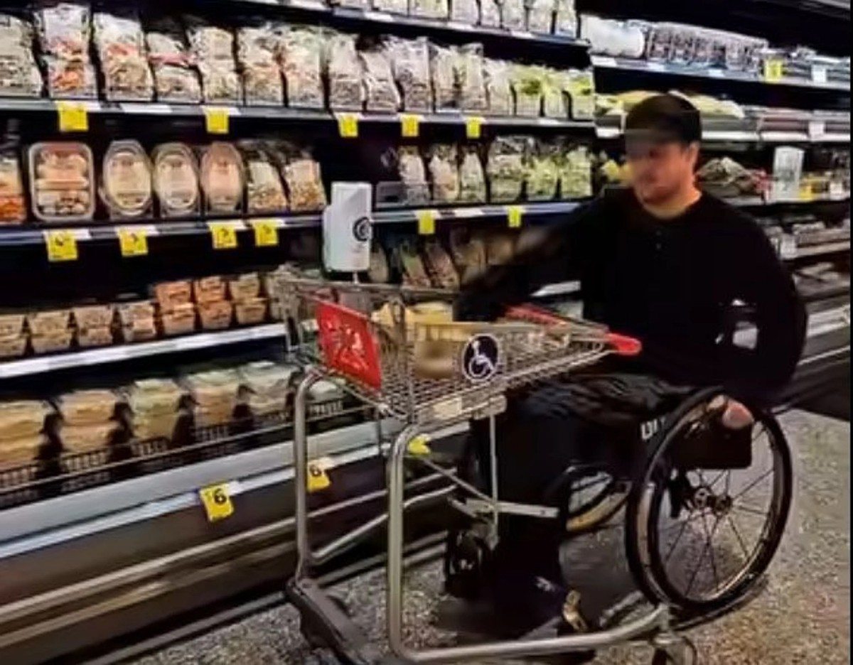 Brennan Noeth testet einen behindertengerechten Einkaufswagen in einem Supermarkt in Australien.