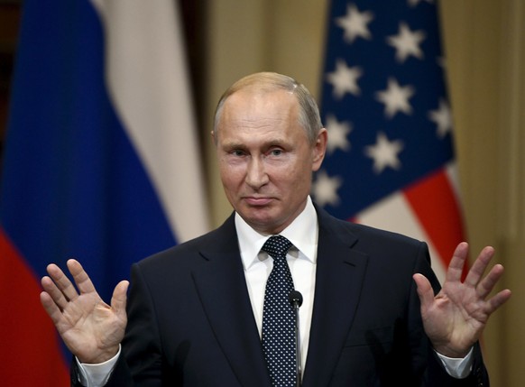 Russian President Vladimir Putin gestures during a joint press conference with U.S. President Donald Trump at the Presidential Palace in Helsinki, Finland, Monday, July 16, 2018. (Antti Aimo-Koivisto/ ...