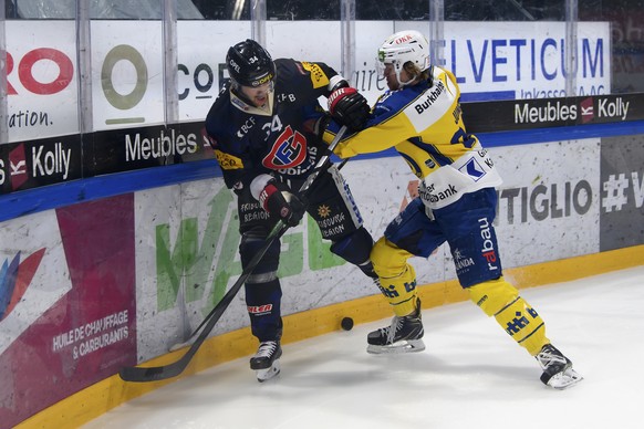 Gotterons Daniel Brodin, links, und Davos? Sven Jung, rechts, kaempfen um den Puck, beim Eishockey Meisterschaftsspiel der National League A zwischen den HC Fribourg Gotteron und dem HC Davos, am Sonn ...