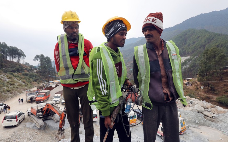 epa10997157 A group of miners with a digging tool arrives at the site of the Silkyara tunnel that collapsed while being under construction, to join in rescue operations, in Uttarkashi, India, 27 Novem ...