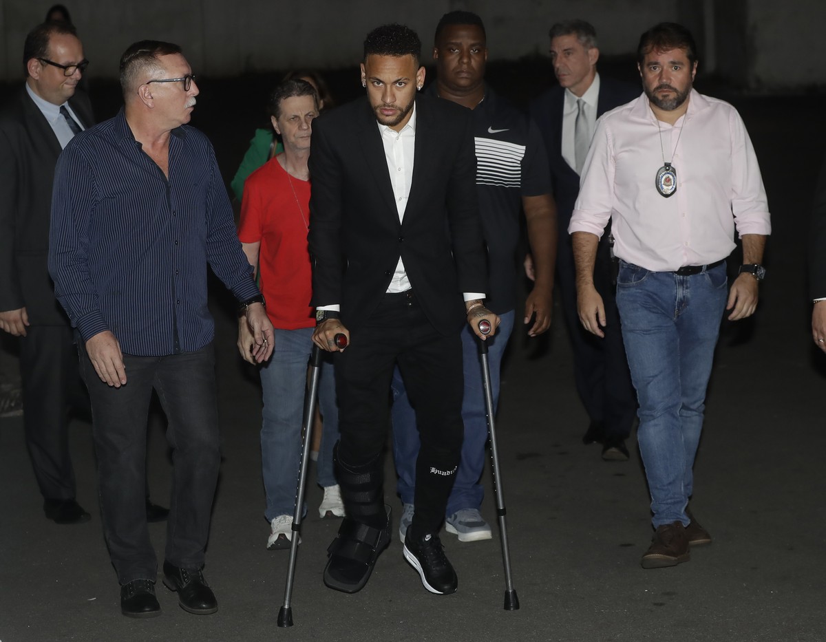 Using crutches because of an injured right ankle, Brazil's soccer player Neymar leaves a police station where he answered questions about rape allegations against him in Sao Paulo, Brazil, Thursd ...