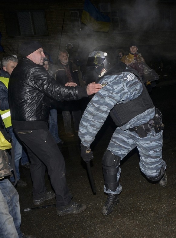 Polizist schlägt mit einem Schlagstock in Kiew auf proeuropäische Demonstranten ein.&nbsp;