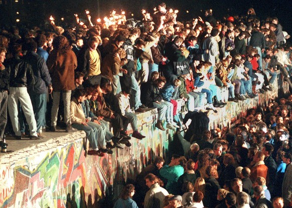 epa04469615 (FILE) A file photo dated 11 November 1989 shows people celebrating the opening of the border between East and West Germany on the Berlin Wall in Berlin, Germany. After the border was open ...