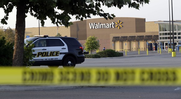 San Antonio police officers investigate the scene where eight people were found dead in a tractor-trailer loaded with at least 30 others outside a Walmart store in stifling summer heat in what police  ...