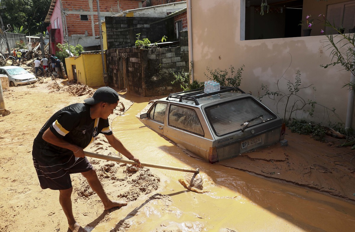 epa10482597 A man tries to rescue belongings after a landslide due to heavy rains in Sao Sebastiao, Sao Paulo state, Brazil, 21 February 2023. At least 44 people died due to heavy rains in Sao Paulo r ...