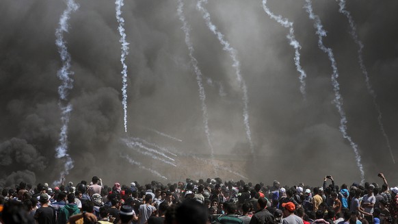 epaselect epa06736016 Israeli army fire tear gas grenades at Palestinian protesters during clashes after protests near the border with Israel in the east of Gaza Strip, 14 May 2018. According to media ...