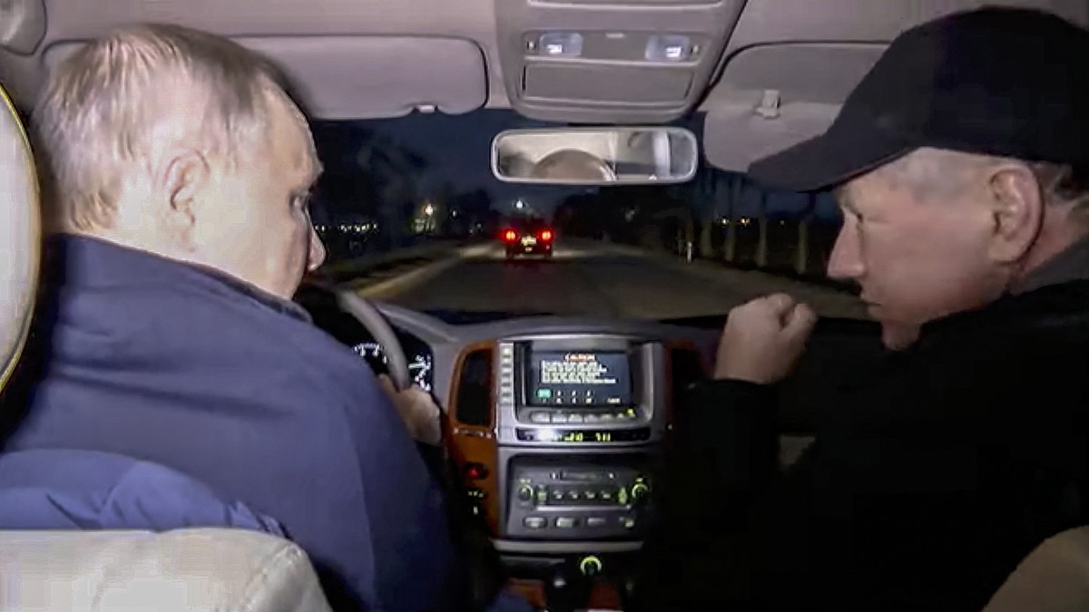 epa10532135 A still image taken from a handout video provided by the Russian President's press service on 19 March 2023 shows Russian President Vladimir Putin (L) drives a car with Deputy Prime M ...