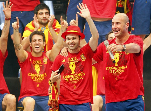Andres Iniesta, centre, Pepe Reina, right, and Cesc Fabregas, left, greet the public during the celebration of the Euro 2012 soccer championship in Madrid, Spain, Monday, July 2, 2012. Spain won the E ...