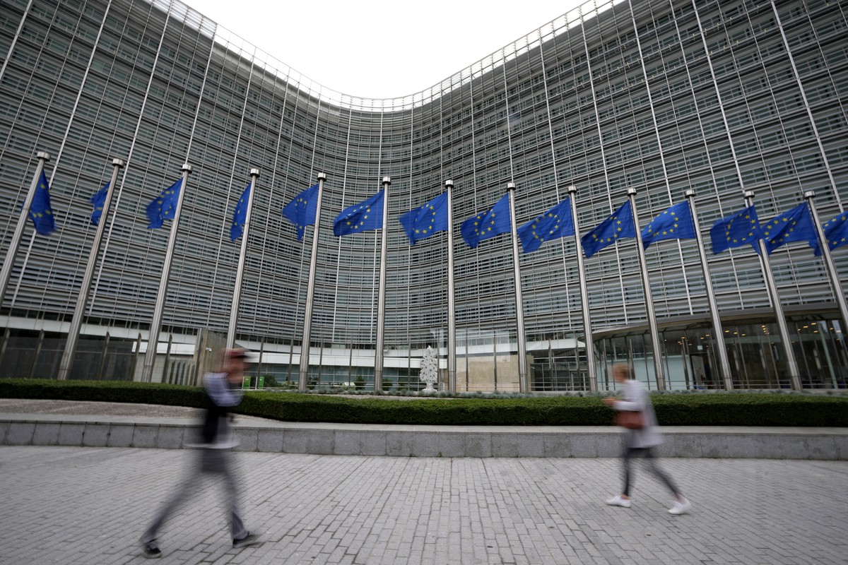 FILE - European Union flags wave in the wind as pedestrians walk by EU headquarters in Brussels, Sept. 20, 2023. (AP Photo/Virginia Mayo, File)