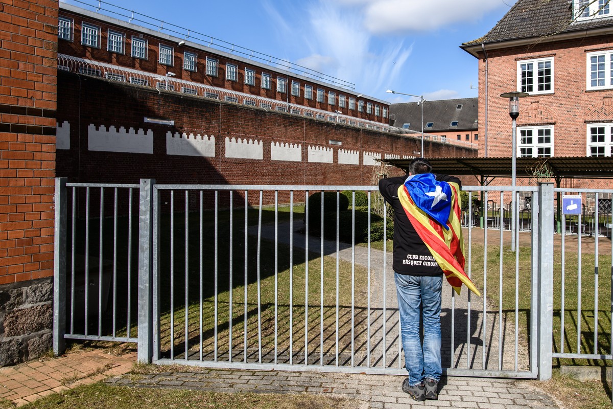 epa06641527 Catalonia sympathizer Eduardo Alonso has an Independence flag wrapped around his shoulders as he leans on an outer fence of the 'Justizvollzugsanstalt (JVA) Neumuenster' prison,  ...