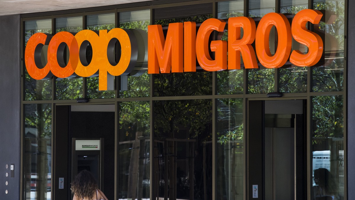 Le logo de la Coop et le logo de la Migros sont photographies cote a cote sur un batiment commercial commun ce mardi 23 aout 2016 sur la place de la Sallaz a Lausanne. (KEYSTONE/Jean-Christophe Bott)