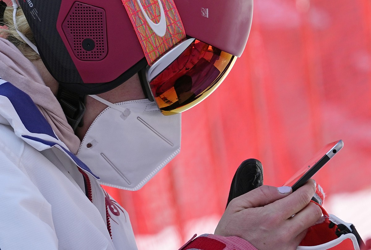 Mikaela Shiffrin of the United States looks at a tablet before heading to the gondola to go up the alpine ski course for a training run at the 2022 Winter Olympics, Thursday, Feb. 10, 2022, in the Yan ...