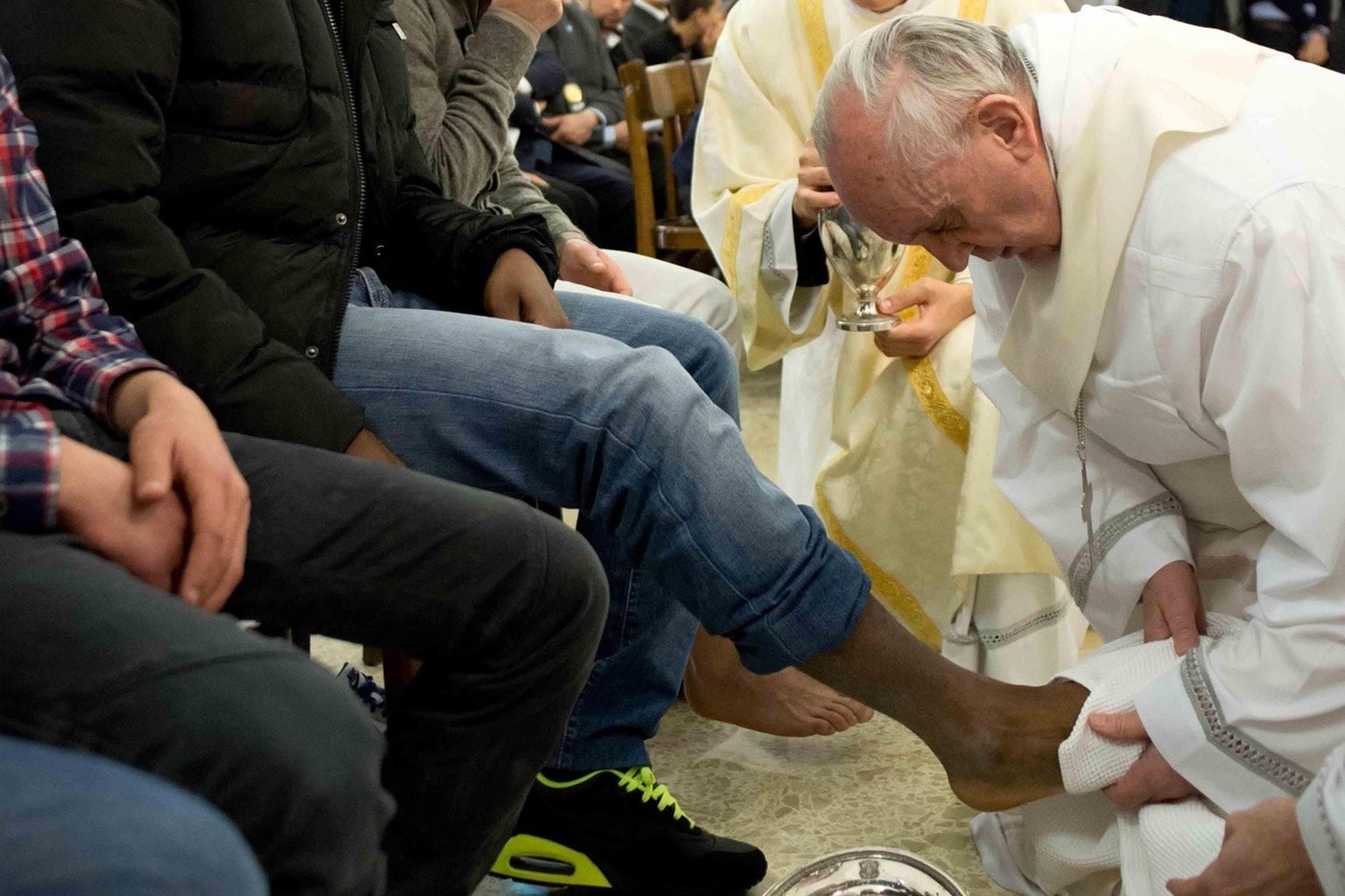 epa03643846 A photo made available by Osservatore Romano shows Pope Francis wiping dry the foot of a young offender during a mass celebrating The Last Supper of Christ in which he washed the feet of p ...