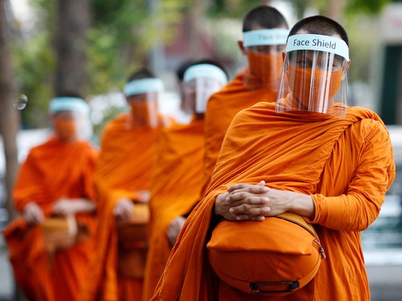 epaselect epa08333378 Thai Buddhist monks wear face shields to prevent the spread of COVID-19 disease caused by the SARS-CoV-2 coronavirus pandemic, during morning alms in Bangkok, Thailand, 31 March 2020. Buddhist monks from Bangkok's Wat Matchantikaram temple have produced their own face shields in an attept to protect themselfs against the spread of SARS-CoV-2.  EPA/RUNGROJ YONGRIT