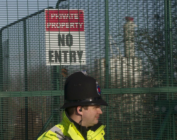 FILE - In this file photo dated Monday, Jan. 13, 2014, a policeman stands outside the entrance to the fracking drill site near Manchester, England. The Cuadrilla company temporarily suspended fracking ...