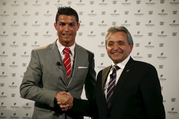 Portuguese player Cristiano Ronaldo shakes hands with Dionisio Pestana, President of the Pestana Group, during a publishing event in Lisbon, Portugal December 17, 2015. The Pestana Group, the largest  ...