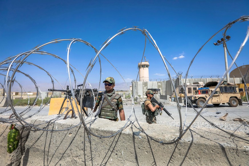 epa09320639 An Afghan National Army (ANA) soldier stands guard at the Bagram Air Base gate, some 50 kilometers north of the capital Kabul, Afghanistan 03 July 2021. After nearly two decades, the US mi ...