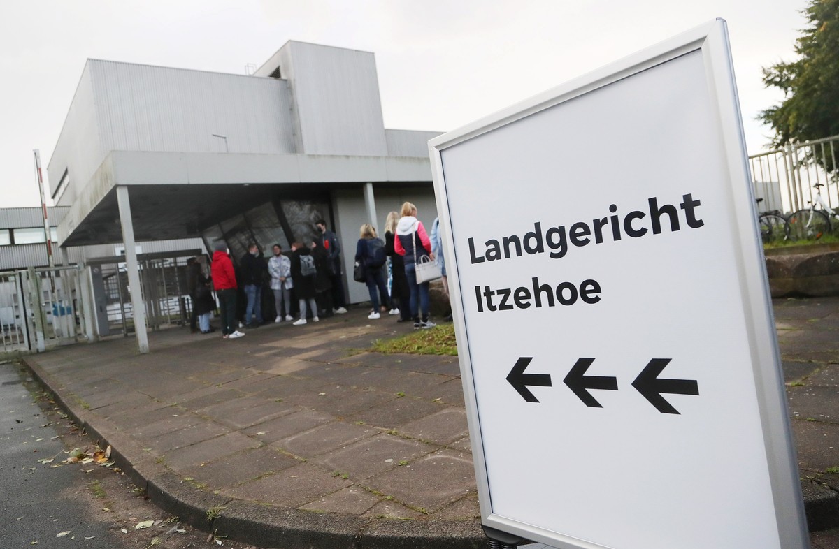 epa09496844 Journalists and spectators queue at the entrance of the premises of the provisional courtroom of the regional court in Itzehoe, northern Germany, 30 September 2021. At juvenile division of ...