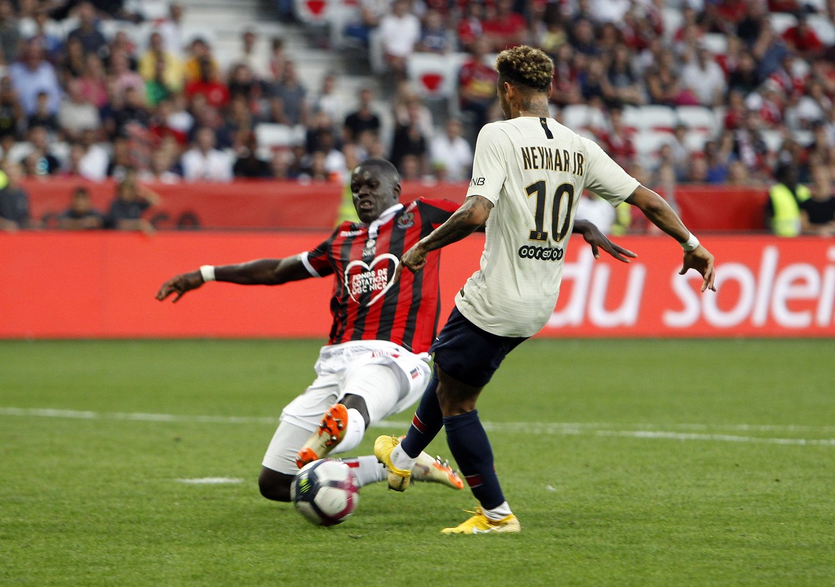Paris Saint Germain's Neymar, right, scores his side's third goal, despite Nice's Malang Sarr, during the League One soccer match between Nice and Paris Saint-Germain at the Allianz Riv ...