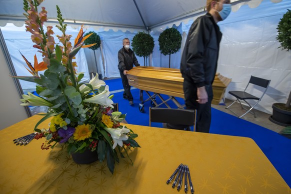 Des employes des pompes funebres amenent un cercueil sous une tente qui fera office de chambre funeraire provisoire, installee dans un entrepot afin que les familles puisse ce recueillir dans l&#039;i ...