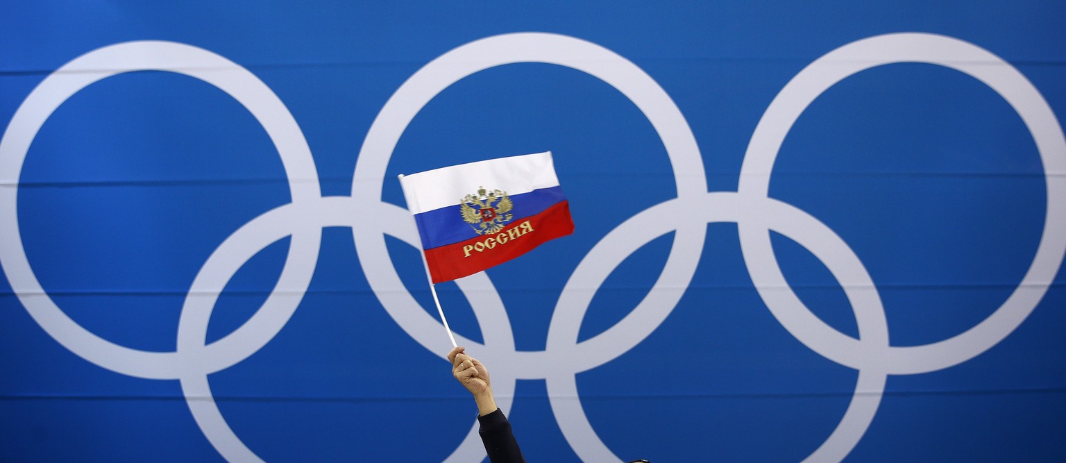 FILE - In this Wednesday, Feb. 21, 2018 file photo a fan waves a flag of Russia before the quarterfinal round of the men&#039;s hockey game between Norway and the team from Russia at the 2018 Winter O ...