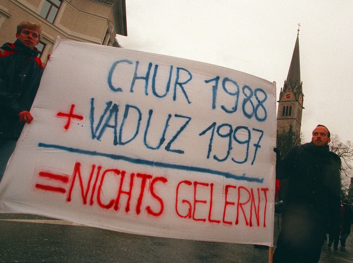 Zwei von 300 Demonstrierenden protestieren am Sonntag nachmittag, 21. Dezember 1997, vor dem Regierungsgebaeude des Liechtensteinischen Hauptorts Vaduz mit einem Transparent gegen die Amtseinsetzung v ...