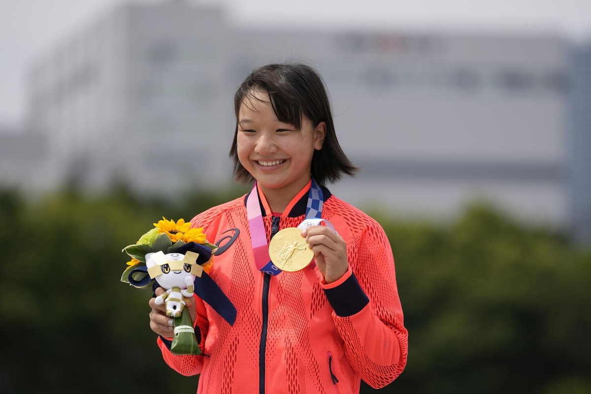 Gold medal winner Momiji Nishiya of Japan holds her medal after winning the women's street skateboarding finals at the 2020 Summer Olympics, Monday, July 26, 2021, in Tokyo, Japan. (AP Photo/Ben  ...