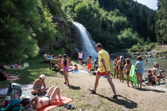 Badende suchen an diesem Hitzetag mit Temperaturen ueber 30 Grad Abkuehlung in den natuerlichen Wasserbecken unter dem Wasserfall Piumogna Wasserfall bei Faido am Mittwoch, 29. Julie 2020. (KEYSTONE/T ...