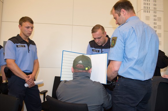 epa05337154 One of the two accused perpetrators (C) in the case of the murder of 17-year-old Annelie in the courtroom at the start of the trial in the district court in Dresden, Germany, 30 May 2016.  ...