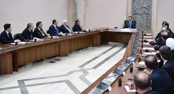 epa05420809 A handout photo made available by Syrian Arab News Agency (SANA) shows Syrian President Bashar Assad (C) during a meeting with members of the newly-formed Cabinet following the swearing-in ...