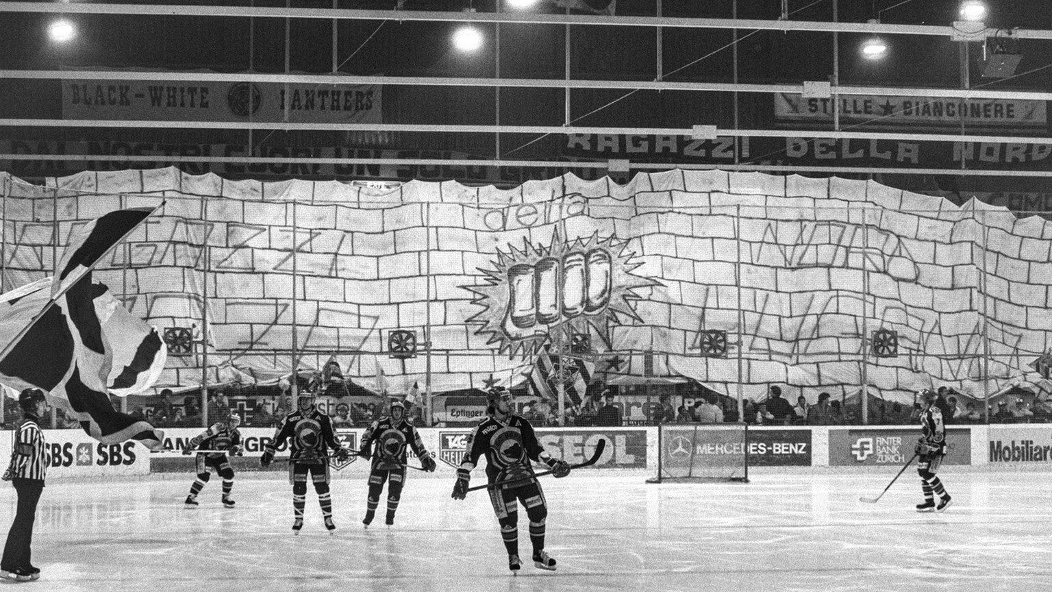 Die HC Lugano Fans spannen ein riesiges Transparent ueber die Zuschauerraenge in der Resega und versuchen die SCB-Spieler auf dem Eis schon vor dem Spiel einzuschuechtern, aufgenommen am 6. Maerz 1990 ...