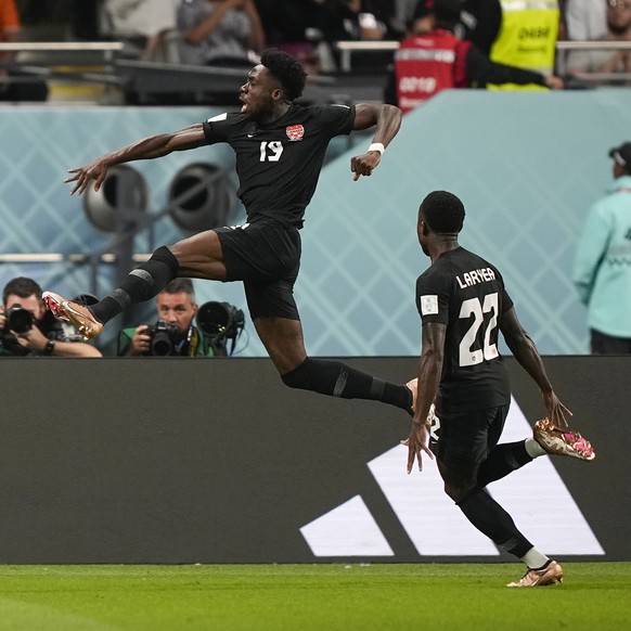 Canada's Alphonso Davies, top, celebrates after scoring the opening goal during the World Cup group F soccer match between Croatia and Canada, at the Khalifa International Stadium in Doha, Qatar, Sund ...
