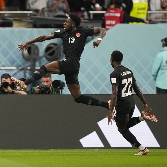 Canada&#039;s Alphonso Davies, top, celebrates after scoring the opening goal during the World Cup group F soccer match between Croatia and Canada, at the Khalifa International Stadium in Doha, Qatar, ...