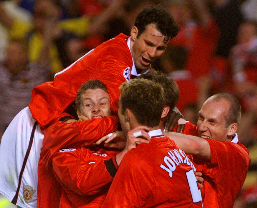 Manchester United&#039;s Ole Gunnar Solskjaer (bottom left) is mobbed by his temmates Ryan Giggs (top), Ronny Johnsen (center) and Jaap Stam after scoring the winning goal in the UEFA Champions League ...