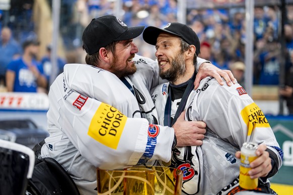 Torhueter Reto Berra und Julien Sprunger (HCFG) feiern den Meistertitel mit dem Pokal nach ihrem Sieg gegen Davos in der Verlaengerung im siebten Eishockey Playoff Finalspiel der National League zwisc ...