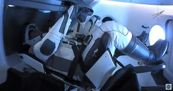 epa08580090 A handout picture made available by the National Aeronautics and Space Administration (NASA) shows NASA astronauts Robert Behnken and Douglas Hurley seated inside the SpaceX Crew Dragon sp ...