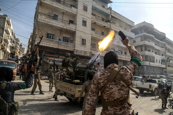 epa06612186 Turkish-backed Free Syrian Army soldiers fire in the air as they celebrate after reportedly capturing the city of Afrin, northern Syria, 18 March 2018. Turkish President Recep Tayyip Erdog ...
