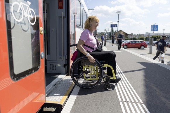 ZUM THEMA MENSCHEN MIT BEHINDERUNG IM OEFFENTLICHEN VERKEHR STELLEN WIR IHNEN HEUTE DIESES NEUE BILDMATERIAL ZUR VERFUEGUNG --- The wheelchair user Ms. Koerner gets off a line 27 commuter train in Doe ...
