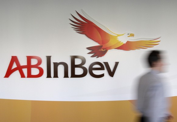 FILE - In this Thursday, March 3, 2011 file photo, a man walks past the AB InBev logos, in Leuven, Belgium. AB Inbev, the world&#039;s biggest brewer with brands like Budweiser and Corona, is selling  ...