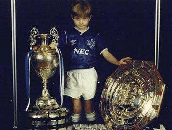 Hätten Sie den Knirps erkannt? Steven Gerrard wurde als Siebenjähriger von seinem Vater dazu gezwungen, sich in ein Everton-Dress zu stürzen und mit dem Meisterpokal zu posieren. Die Begeisterung steht dem ewigen Captain des FC Liverpool geradewegs ins Gesicht geschrieben.