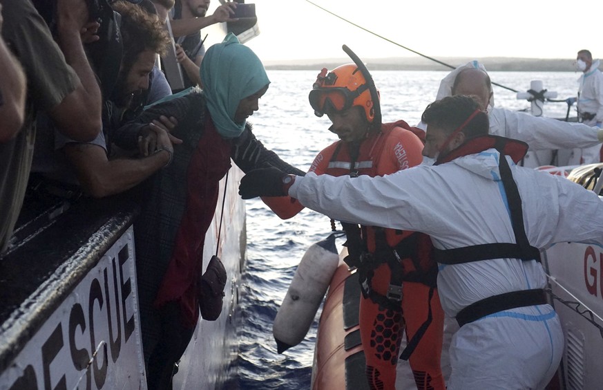 Migrants are evacuated by Italian Coast guards from the Open Arms Spanish humanitarian boat off the coast of the Sicilian island of Lampedusa, southern Italy, Thursday, Aug. 15, 2019. A Spanish aid bo ...