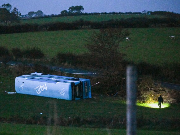 epa11648176 A Translink double-decker bus, which overturned while carrying 43 school children, is seen behind the police cordon in Newtownards of County Down, Northern Ireland, 07 October 2024. The No ...