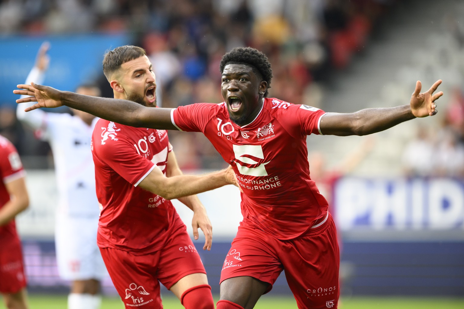 Le milieu du SLO Giovani Bamba, droite, celebre son but du 0 a 2 avec le defenseur du SLO Lavdrim Hajrulahu, gauche, lors de la rencontre de football du match aller de barrage de promotion en Super Le ...